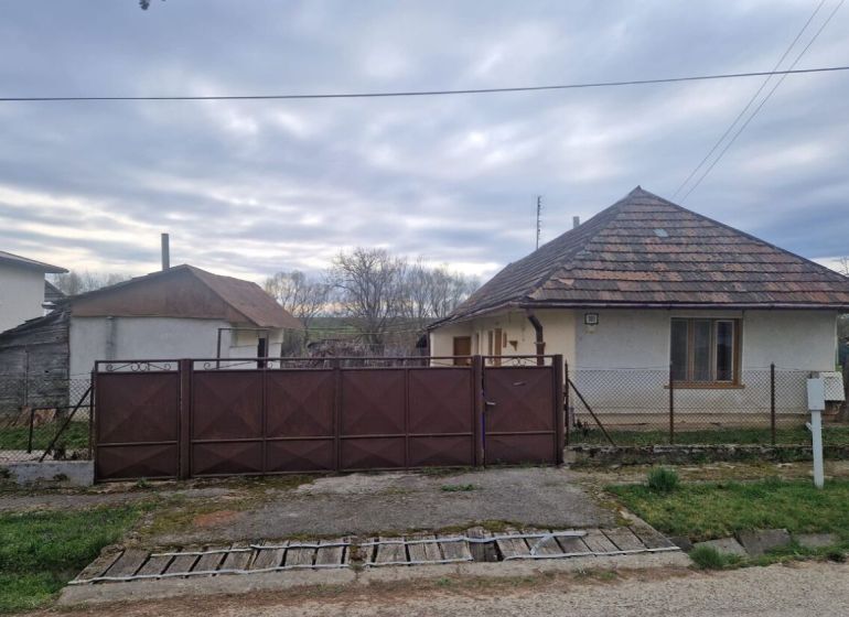 Rodinný dom s veľkým pozemkom v obci Kolta - Rodinný dom v Kolte s bránou, plotom a sedlovou strechou v pokojnom prostredí.