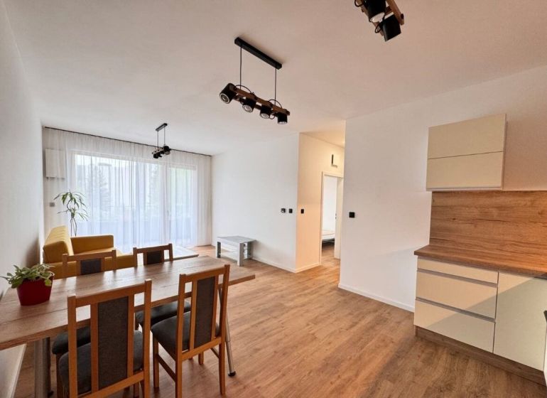 Prenájom nový 2-izbový byt -49m² Žilina-Vlčince, EUROTERRACE - Jasný obývací priestor s jedálenským stolom a podlahou s dreveným dekorom.