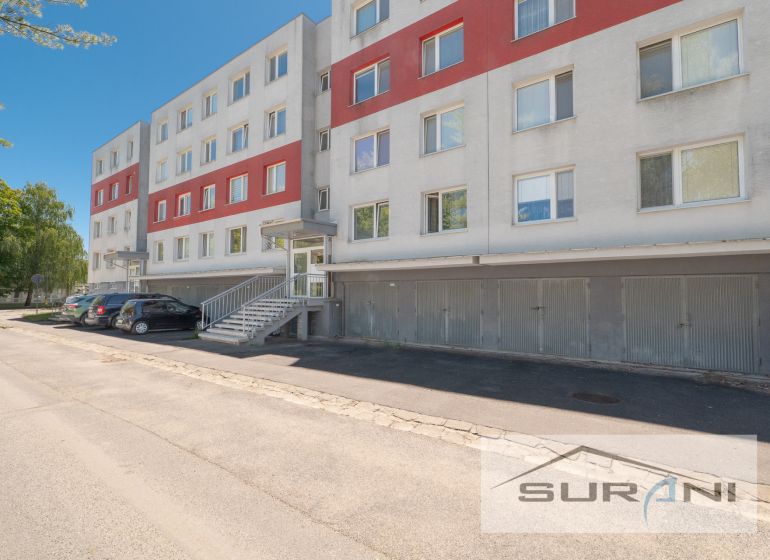 PREDAJ | 4-izbový byt s loggiou | Bullova ulica | Bratislava - Bytový dom na ulici Bullova v Bratislave-Dúbravke pred 4-izbovým bytom so zaparkovanými autami.