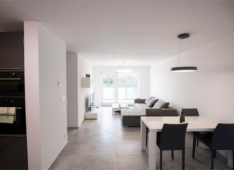 Na Prenájom krásny klimatizovaný mezonet v Pezinku 1.100,- Eur - Obývačka 4-izbového bytu na ulici Trnavská s pohovkou, jedálenským stolom a spotrebičmi.