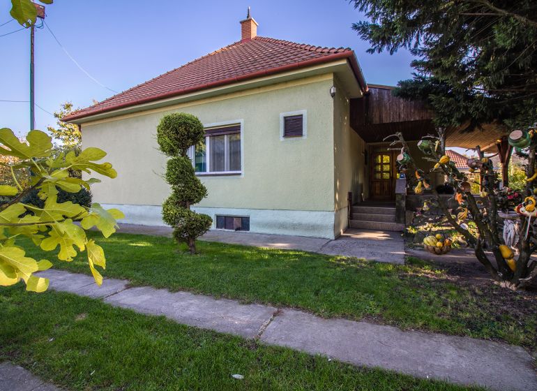 Kúpte si PÔVABNÝ 4i RD na SKVELOM POZEMKU s GARÁŽOU a HALAOU - Rodinný dom na ulici Malý Máger, pred ním záhrada s upravenými kríkmi.