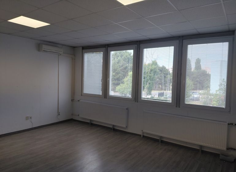 Klimatizovaná kancelária 39 m2 s umývadlom na Tomášikovej ul.  - Prázdna miestnosť s podlahou s dreveným dekorom, oknami a klimatizáciou v Kanceláriách.