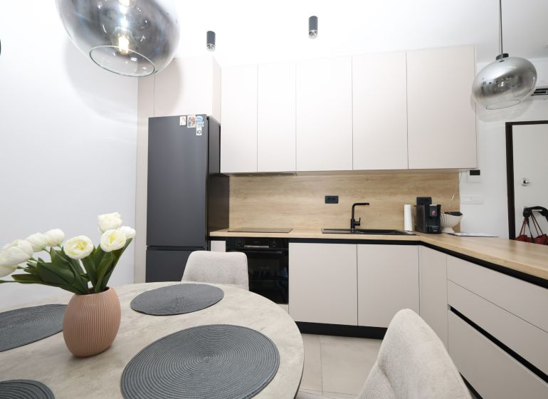 Chorvátsko, Vodice - zariadený apartmán s výhľadom na more - Kuchyňa v rekreačnom apartmáne so zabudovanými spotrebičmi a jedálenským stolom s dekoračnými doplnkami.