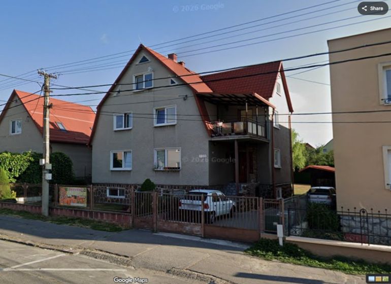 DOBRÉ REALITY - Výhodné dlhodobé ubytovanie v Bojniciach - Rodinný dom na Prievidzskej ulici v Bojniciach s červenou strechou a autom v dvore.