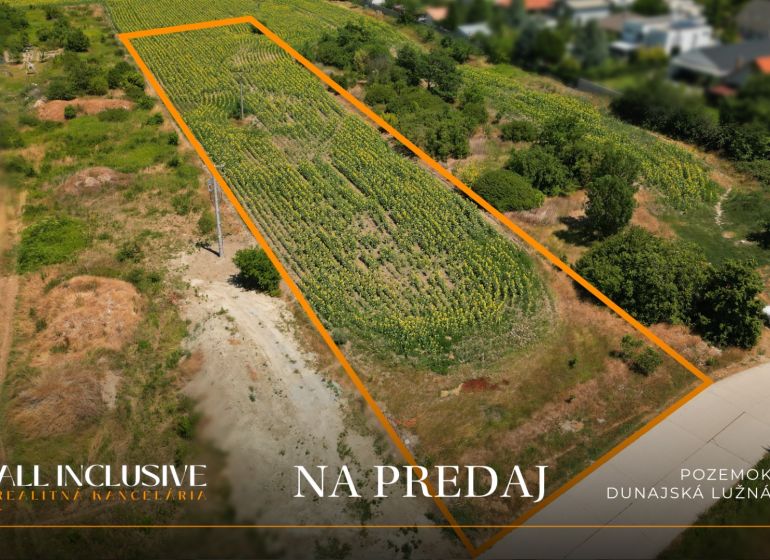 Na predaj stav. pozemok s projektom, Dunajská Lužná - Letecký pohľad na pozemok pre bývanie v Dunajskej Lužnej, obklopený zeleňou.