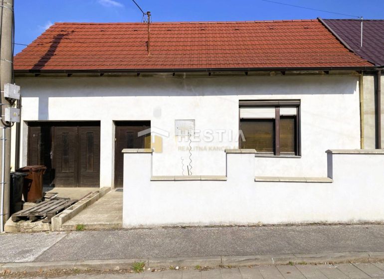 NA PREDAJ 3-izb. rodinný dom, slnečný pozemok, Senica – Kunov - Rodinný dom v Senici s tehlovou strechou, garážou a bielou fasádou.