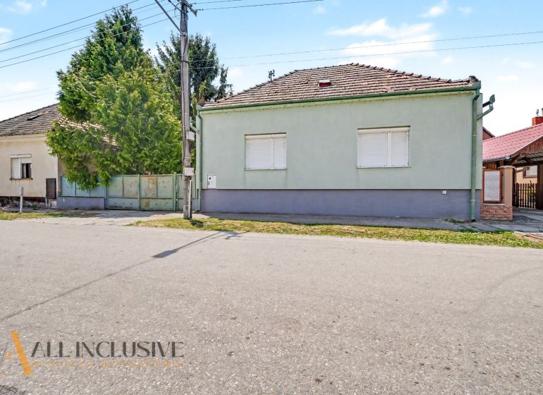 Na predaj 5-izb.rd vhodný na dvojgen. býv., Topoľníky - Rodinný dom v Topoľníkoch so zeleným plotom a škridlovou strechou.