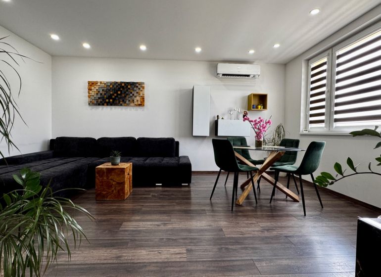 3-izbový byt | 79 m² | Komárno – sídlisko gen. Klapku - Obývačka 3-izbového bytu s nábytkom, podlahou s dreveným dekorom a izbovými rastlinami.