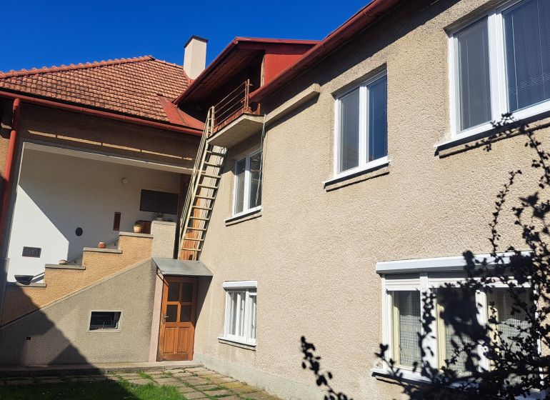 RODINNÝ DOM, pozemok 290m2,  MEDZIBROD okr. Banská Bystrica   - Rodinný dom v Medzibrode s vonkajším schodiskom a bielymi oknami.