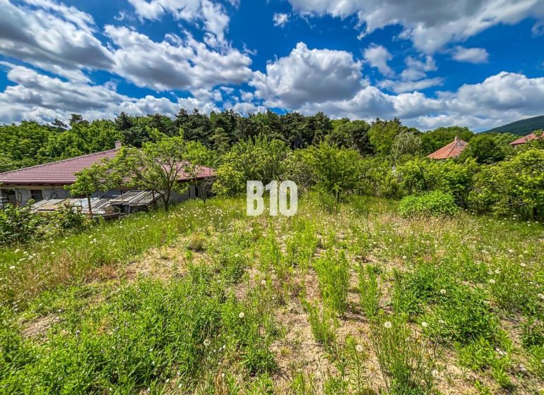 Stavebný pozemok 750 m² v Kolíňanoch – pokojné bývanie v príjemnom pro - Pozemky - bývanie v Kolíňanoch so zeleňou, okolité domy a čiastočne zamračená obloha.