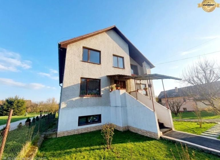 NA PREDAJ rodinný dom Hrnčiarska Ves okr.POLTÁR - Rodinný dom v Poltári s bielou fasádou, zeleným trávnikom a prístreškom nad schodiskom.