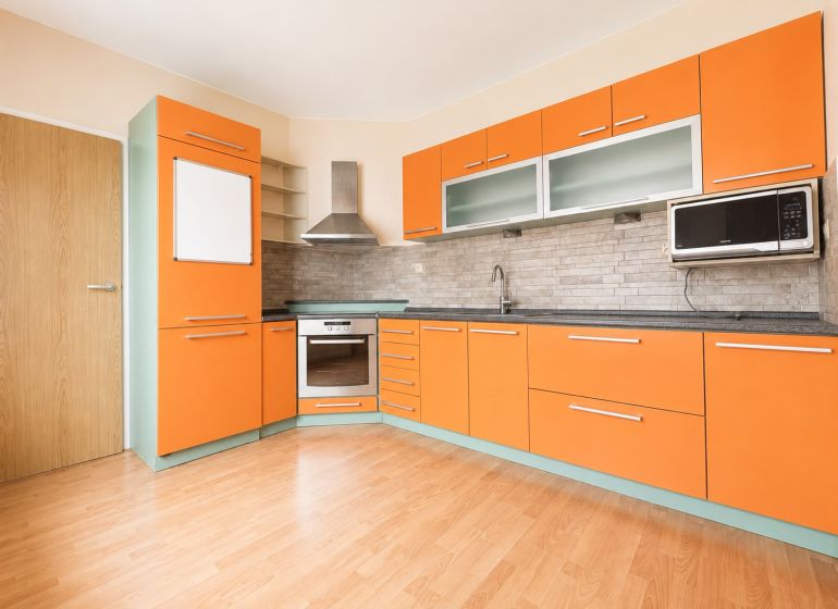 Predaj! slnečný 3-izbový byt s loggiou 74 m² Podbreziny - LM - Kuchyňa s oranžovými skrinkami, podlaha s dreveným dekorom, 3-izbový byt.