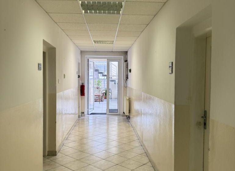 Kancelária 22m2 v menšej administratívnej budove v areáli pri Bozine. - Kancelárske priestory s keramickou dlážkou a bielymi stenami, jasné osvetlenie, dostupné zariadenie.