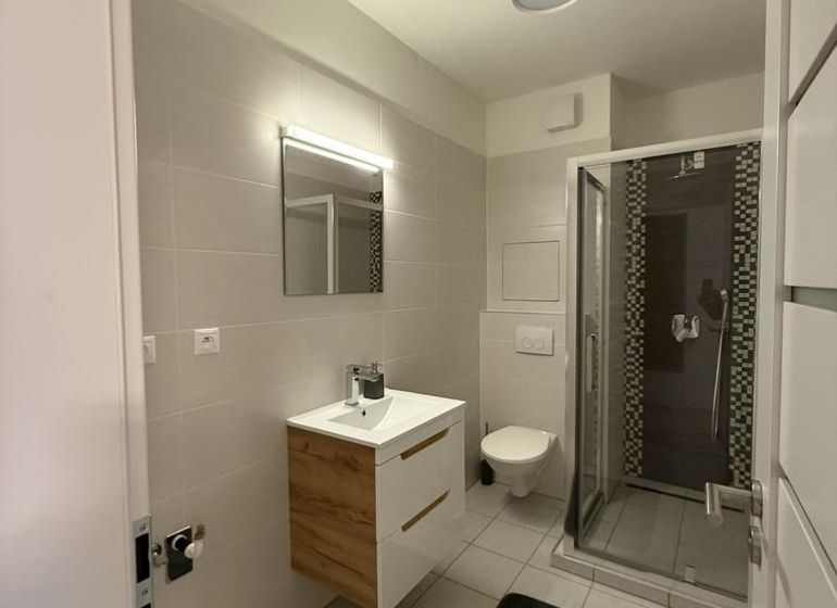 Nové skolaudované byty a apartmány vo Vajnoroch. - Kúpeľňa so sprchovým kútom, umývadlom a zrkadlom, 2-izbový byt s dlažbou.