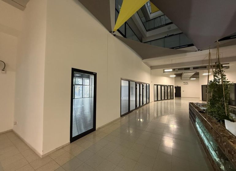 Nové skolaudované byty, apartmány a obch.priestory vo Vajnoroch. - Interiér administratívnej budovy s presklenými kanceláriami, dlažba na podlahe a zeleňou.