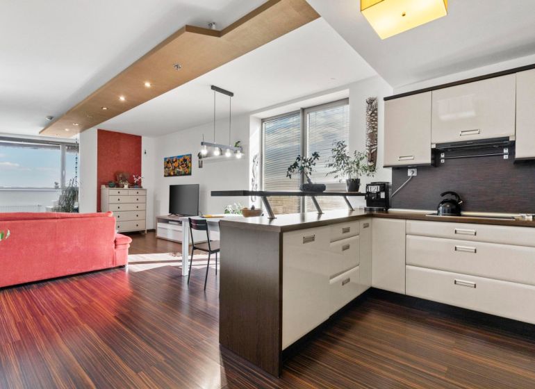 Apartmán vhodný na Airbnb aj rodinné bývanie | Vienna Gate - Kuchyňa v 3-izbovom byte s podlahou s dreveným dekorom a svetlým nábytkom.