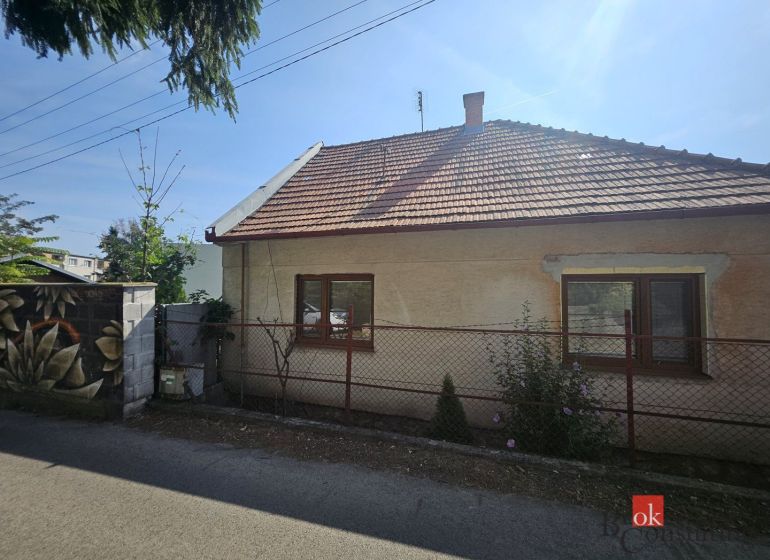 EXKLUZÍVNE NA PREDAJ 2-izbový rodinný dom v širšom centre Nitry s pote - Rodinný dom na Stračej ulici v Nitre s bielou fasádou a šikmou strechou.
