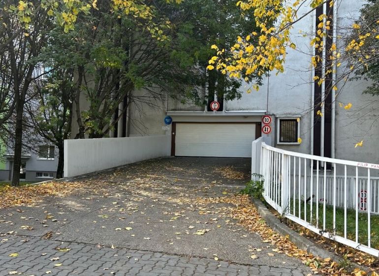 Nadštandardne veľká garáž na ul. Medveďovej, Petržalka - Vchod do garáží na Medveďovej ulici v Bratislave - Petržalke, obklopený jesennými stromami.