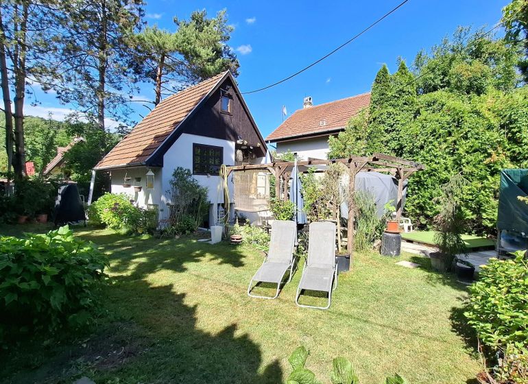 Záhradná chata so záhradou, Devínska cesta, Devín - Záhrada pri chate v Bratislave - Devíne s ležadlami a pergolou, obklopená zeleňou.