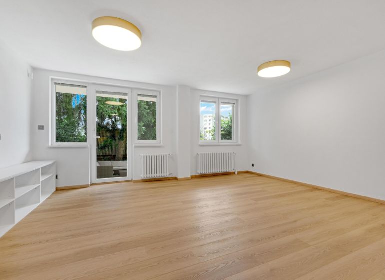 ,Prenájom moderný 3 izb. byt, Sološnícka ul,124 m2, Karlova Ves - Obývacia izba s podlahou s dreveným dekorom v rodinnom dome, presvetlená izbovými oknami.