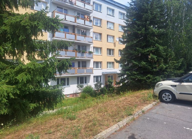 Slnečný 1-izbový byt  na predaj, 42 m2,  J. Gagarina, Zvolen - Bytový dom na Ulici J.Poničana v Zvolenskej Slatine obklopený stromami a zaparkovaným autom.
