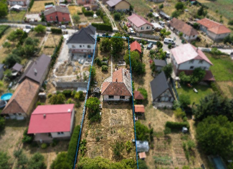 3 izbový Rodinný dom v Cabaj-Čápore s pozemkom 1 053 m² - Letecký pohľad na rodinný dom v Cabaj-Čápore so záhradou a okolitými domami.