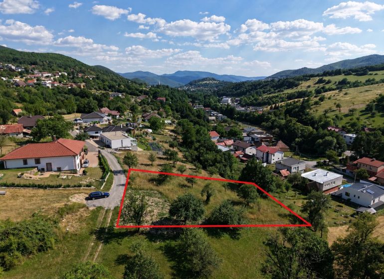 Ideálny Stavebný pozemok 1 353 m² pri Tajchu s krásnymi výhľadmi - Pozemky - bývanie v Novej Bani, obklopené zeleňou a kopcovitým terénom.