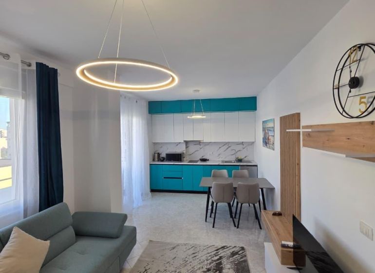 Albánsko, Durres - zariadený apartmán len 100m od mora a pláže - Obývacia izba 2-izbového bytu so štýlovým osvetlením, kuchyňou a pohodlnou sedačkou.