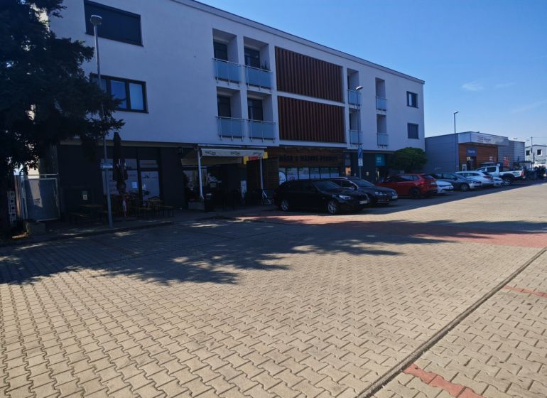 Moderný 2- izbový byt na prenájom , Rohožník - Budova na Senickej ulici v Rohožníku s parkovacími miestami v popredí.