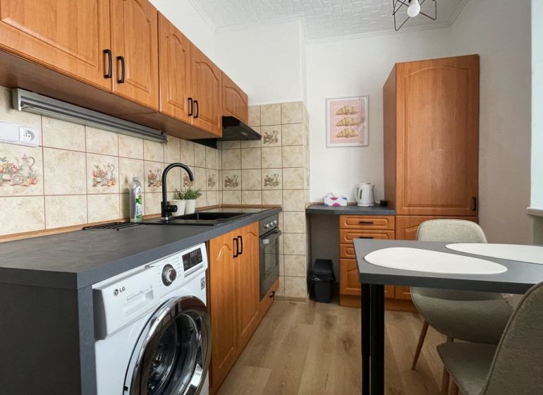 Prenájom 2-izbový byt s balkónom Martin – Podháj (41m2) - Kuchyňa v 2-izbovom byte s podlahou s dreveným dekorom a linkou so spotrebičmi.