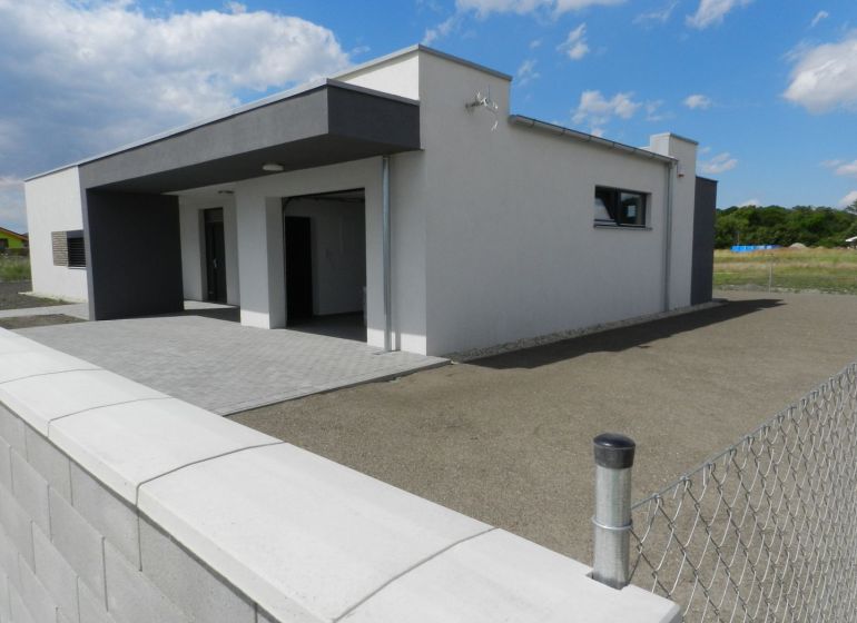 4. ETAPA!!! MODERNÁ NOVOSTAVBA - 3 izbový nízkoenergetický bungalov vy - Rodinný dom v Dolnom Bare s plotom a spevnenou plochou pod modrou oblohou.
