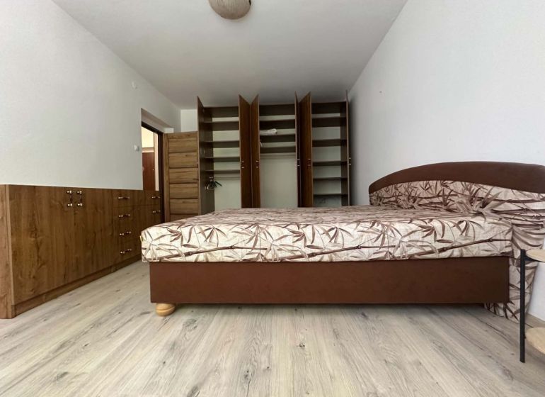 ☎️ 0918197701 Na prenájom  zariadený 1 izbový byt  na sídlisku západ n - Spálňa v 1-izbovom byte s posteľou, otvorenou skriňou a podlahou s dreveným dekorom.