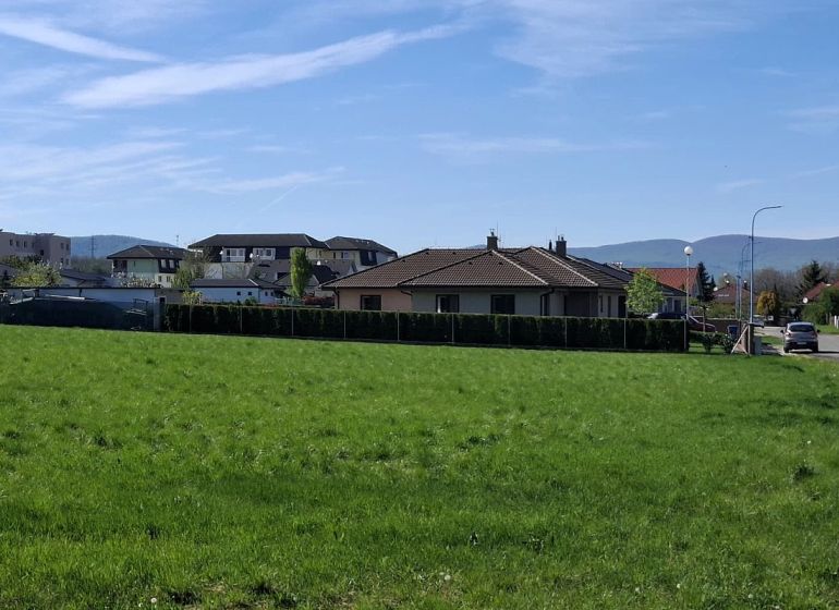 Stavebný pozemok 1212m² v obci Šelpice - Pozemok na bývanie na Slnečnej v Šelpiciach s výhľadom na domy a zeleň.
