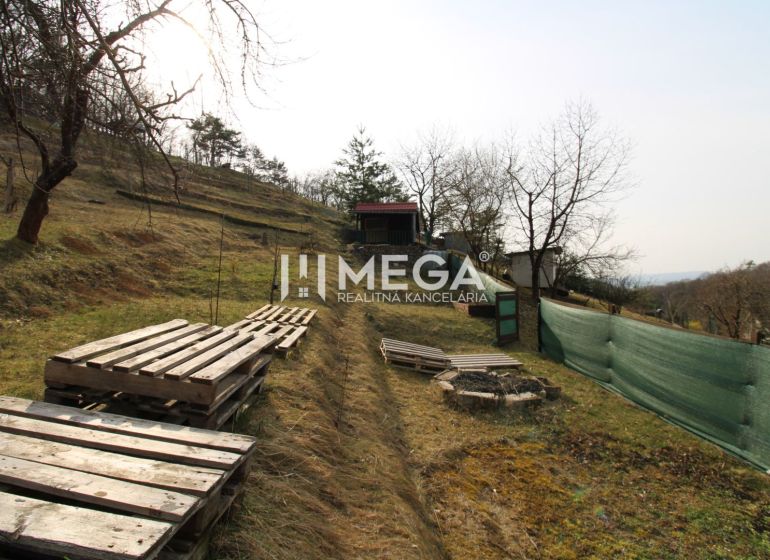 NA PREDAJ pozemok 800m2 v ZO Poniklec pri meste Humenné - Záhrady v Humennom na ZO Poniklec, trávnatý svah s paletami a dreveným altánkom.