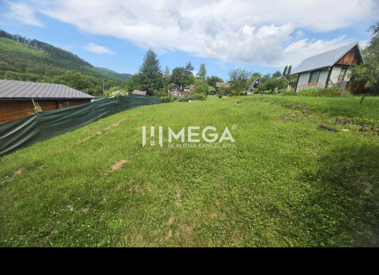 Záhrada na predaj – 365 m², Pichoňka, Snina - Záhrady v Snine na Snine s trávnikom, oplotením a výhľadom na hory v pozadí.