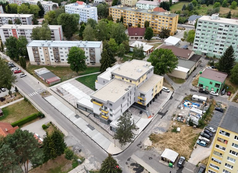 3-izbový byt s balkónom v Rezidencii Madone - Pohľad na obytnú ulicu Školská v Hriňovej s 3-izbovými bytmi a zelenými plochami.