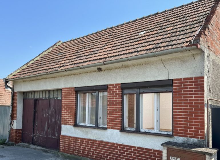 RD s veľkorysým pozemok s obrovským potenciálom v Dolných Orešanoch - Rodinný dom v Dolných Orešanoch na ulici Dolné Orešany, s červenou tehlovou fasádou.