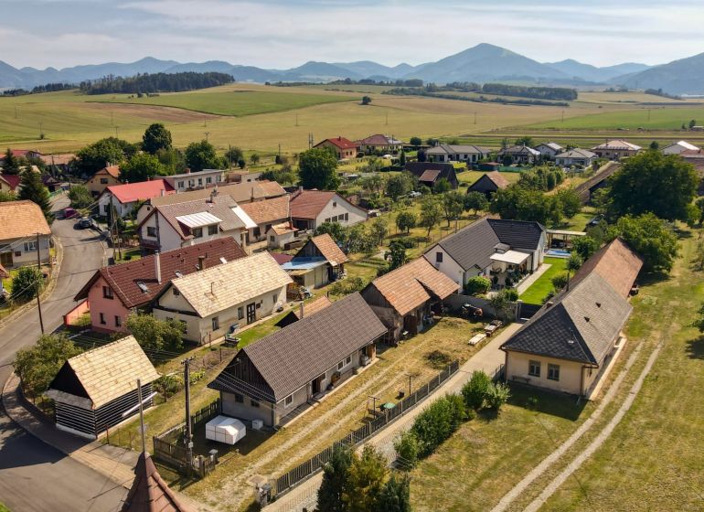 Rezervované - Tradičná drevenica s potenciálom v Žabokrekoch - Žabokreky: Panoráma rodinných domov s vidieckym charakterom a kopcami v pozadí.