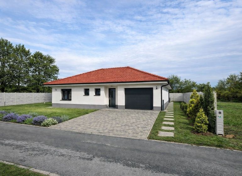 / Novostavba, moderný bungalov, dokončený na kľúč  - Rodinný dom v Senci s červenou strechou, garážou a udržiavanou záhradou.