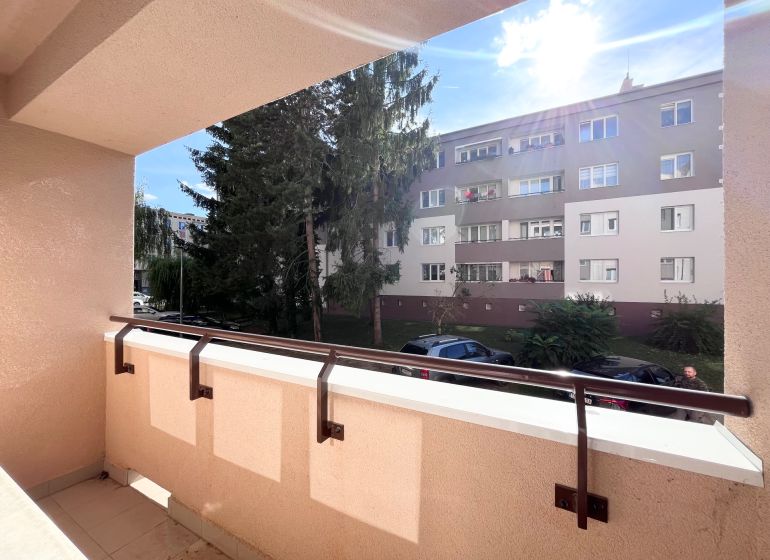 NA PRENÁJOM! Slnečný a zariadený 3i byt 68 m2, ul. Švermova, Trenčín - Balkón 3-izbového bytu na Švermovej ulici, Trenčín s výhľadom na okolitú budovu.