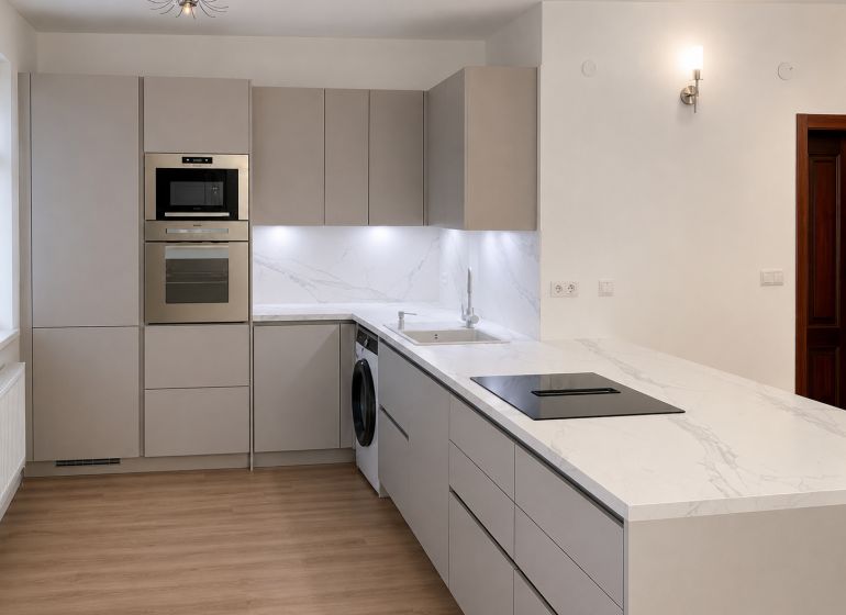 Priestranný a kvalitne zariadený 3-izbový byt – Bratislava, Petržalka - Kuchyňa v 3-izbovom byte s podlahou s dreveným dekorom a modernými spotrebičmi.