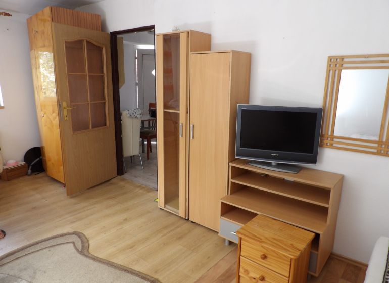 Nájomné bývanie v centre Serede - Obývacia izba v 2-izbovom byte s nábytkom a podlahou s dreveným dekorom.