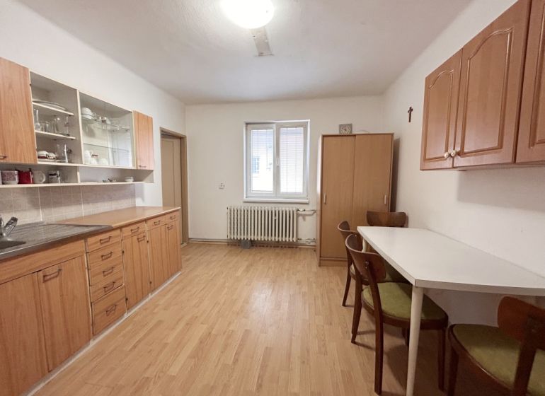 RD NA BÝVANIE AJ PODNIKANIE,1630m2,  SABINOVSKÁ Ul., PREŠOV - Kuchyňa v rodinnom dome s podlahou s dreveným dekorom, drevenými skrinkami a jedálenským stolom.