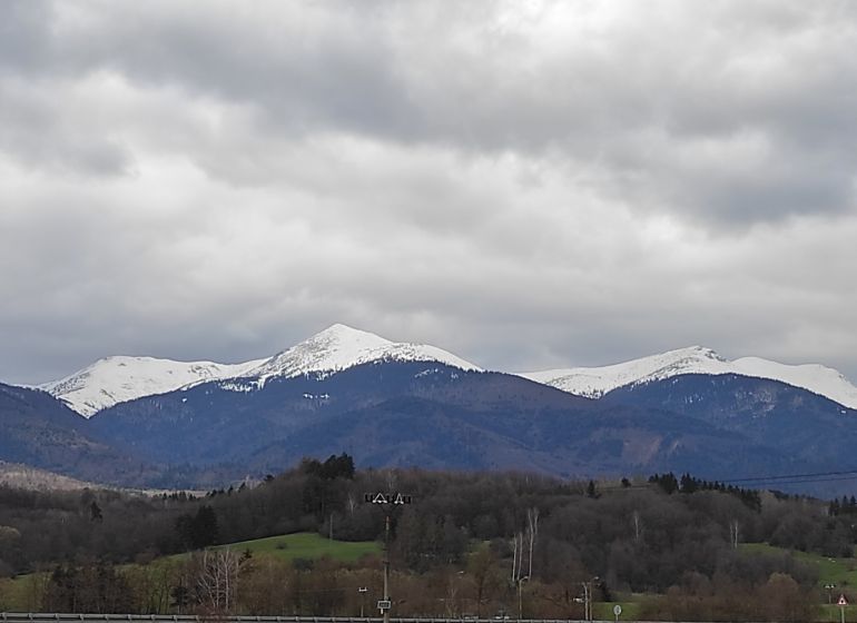 TURANY-veľký rekreačný pozemok v blízkosti časti TRUSALOVÁ 7667 m2 - Scénický výhľad na zasnežené pohorie a rekreačné pozemky pod oblačnou oblohou.