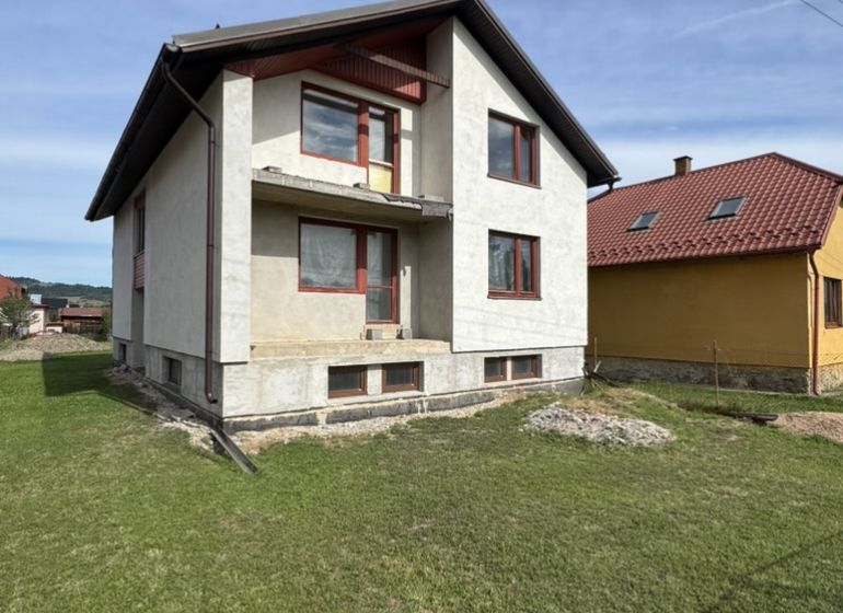 Rozostavaný rodinný dom Plavnica - Rodinný dom v Plavnici so zeleným trávnikom a čiastočne dokončenou fasádou.