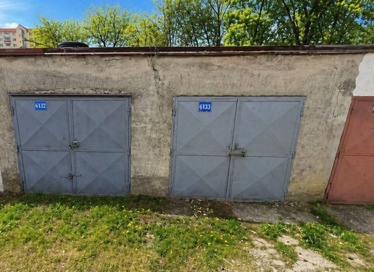 PREDAJ - Murovaná garáž v rad. zástavbe na Gašparíkovej ulici, Ružinov - Garáže na Gašparíkovej ulici v Bratislave-Ružinove, obklopené trávou a stromami.