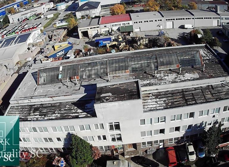 BRATISLAVA III. - RAČA - NA PREDAJ - priemyselný objekt s polyfunkčnou - Výrobné priestory na Staviteľskej ulici v Bratislave III s priemyselnými budovami v pozadí.