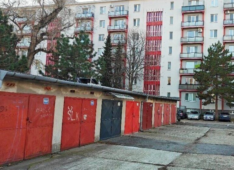 Predaj - Garáž na Haburskej ulici pri Štrkovci - Garáže na Haburskej ulici v Bratislave - Ružinove pred bytovým domom s balkónmi a stromami.