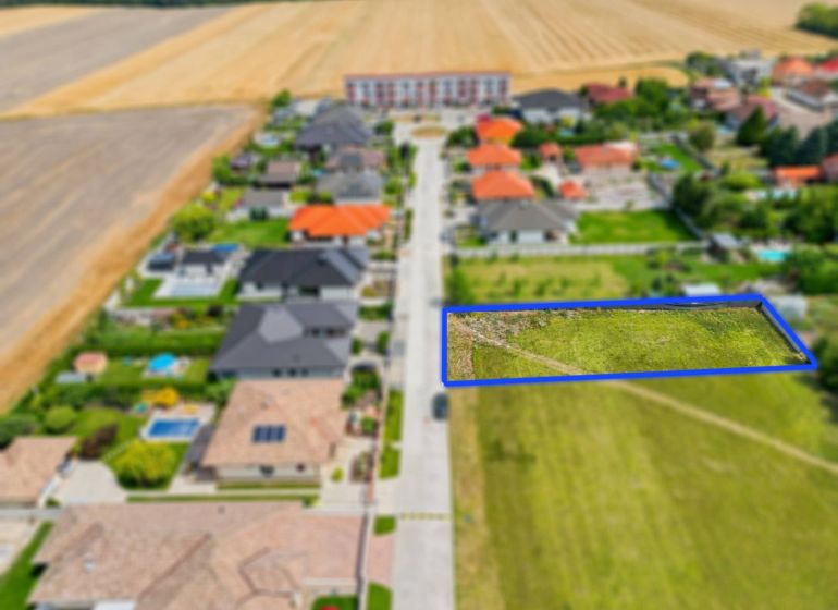 Stavebný pozemok v novej štvrti obce Ohrady – 969 m² - Letecký pohľad na pozemky pre bývanie v Ohradoch lemované domami s dvormi.