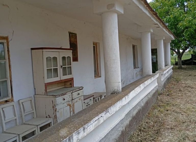 Vidiecky domček na predaj. - Starší rodinný dom v Ňárade s verandou a vintage nábytkom pred domom.